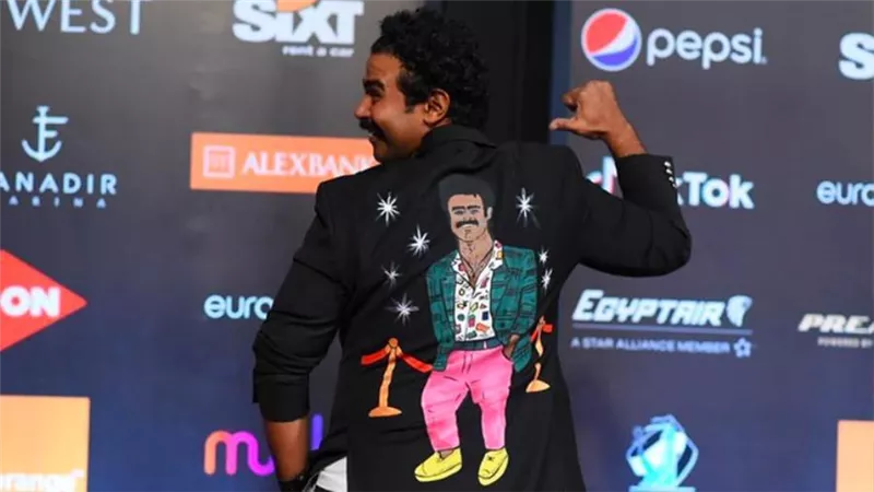 إسلام إبراهيم يرد على منتقدي إطلالاته بصورته مرسومة على ظهره
